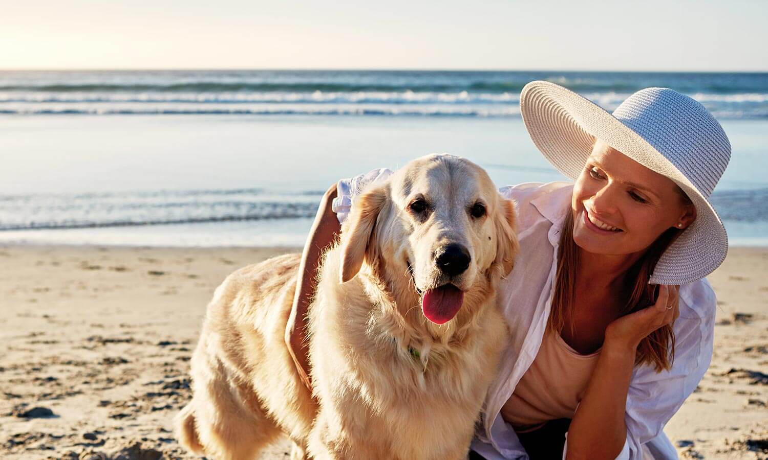 A woman and dog on the beach